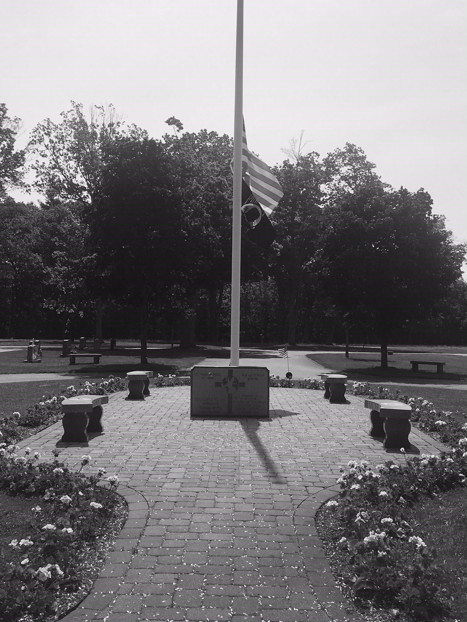 Veterans circle in Gibson cemetery with flags waving in Black & White