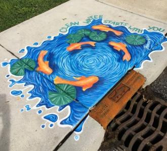 Picture of storm water drain mural with fish circling drain